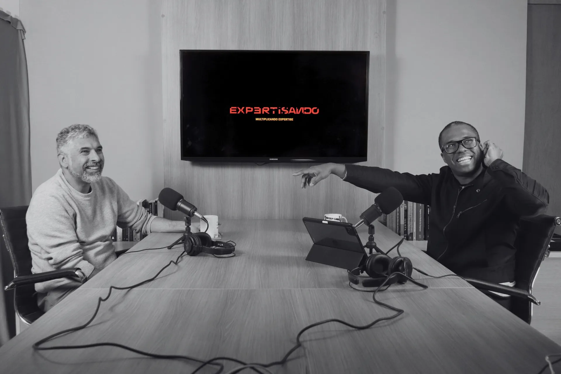 Gravação do podcast Expertisando: dois convidados rindo em frente aos microfones